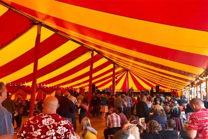 Group of people in a big stripy tent
